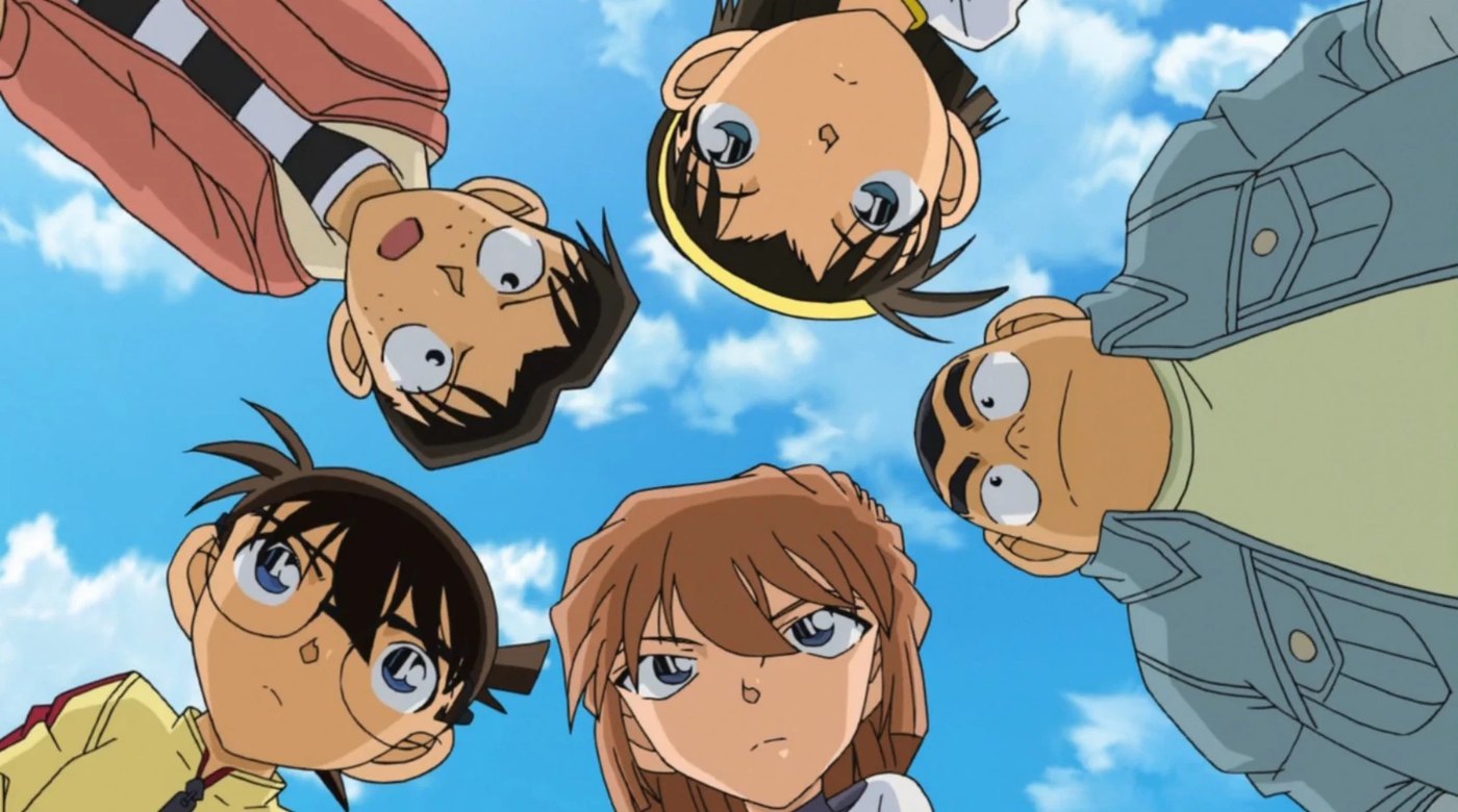 Conan Edogawa and the Detective Boys look down at the camera against a blue sky