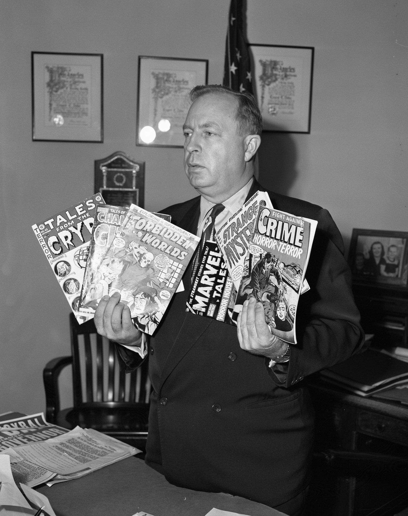 Los Angeles councilman Ernest Debs holding crime comic books in 1954