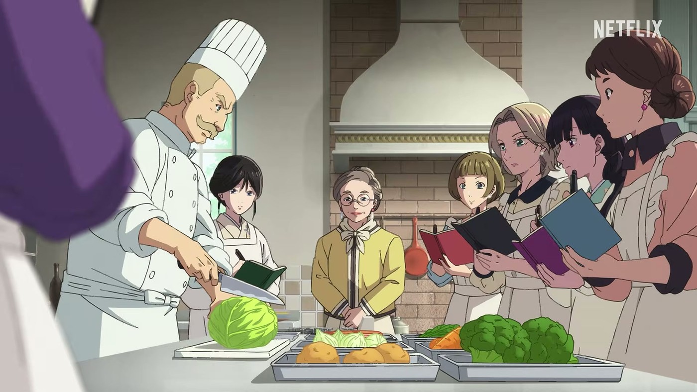 A chef in whites chopping cabbage in a brick-ovened kitchen while several women holding notebooks look on