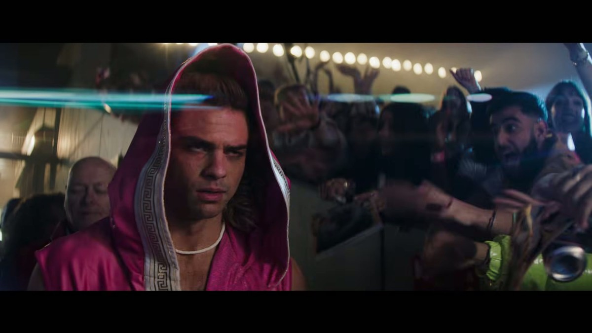 A fighter in a pink hooded entrance robe in a crowd