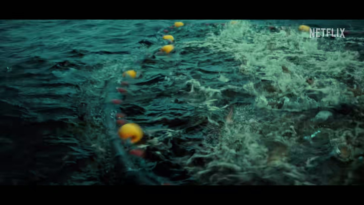 Water churning white inside a line of yellow net floats in the Below trailer