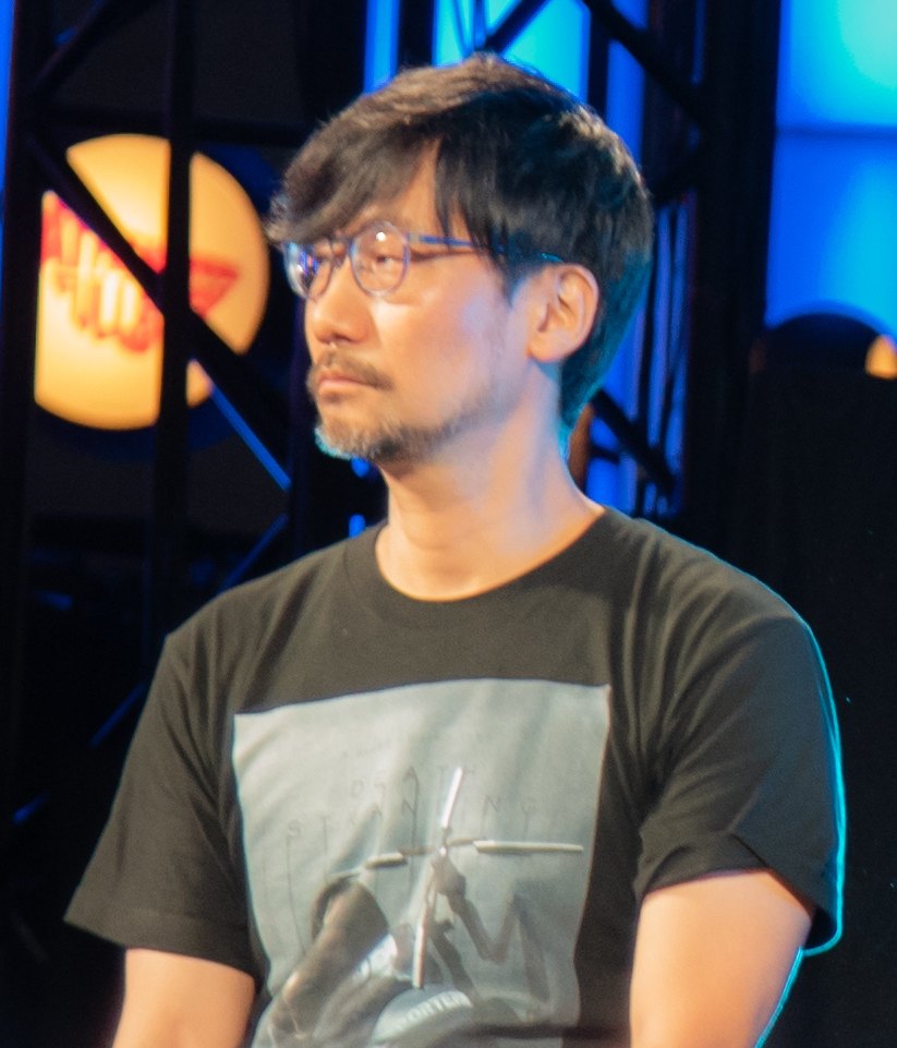 Hideo Kojima wearing a Death Stranding shirt on stage in 2018