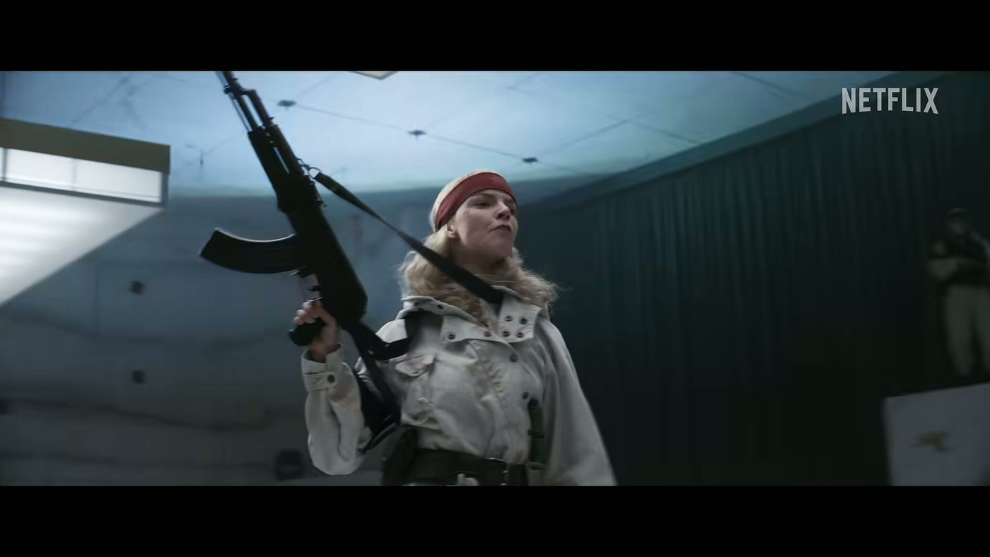 A cult member in a shearling coat holding a rifle in the Sacrifice trailer