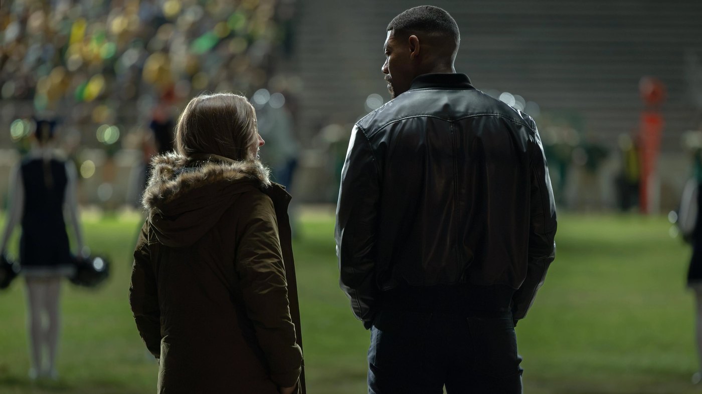 Kerry Kane and Noah on a football field in the Lanterns finale, Dirt and Stars